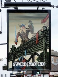 The sign of The Swordsman Inn, next to the 18th century bridge at Stamford Bridge.